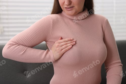 Preview: Mammology. Woman doing breast self-examination indoors, closeup