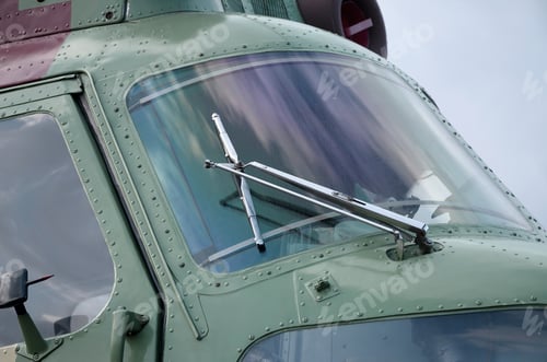 Preview: Helicopter cabin fragment close up. Camouflage aircraft fuselage and bulletproof glass