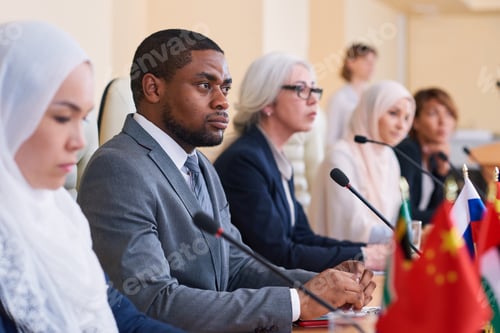 Preview: African-american businessman listening attentively to one of speakers report