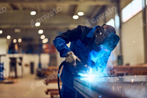 Preview: Worker Welding Metal in Industrial Workshop with Protective Gear and Bright Sparks