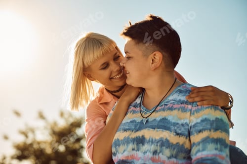 Preview: Young lesbians in love outdoors against the sky.
