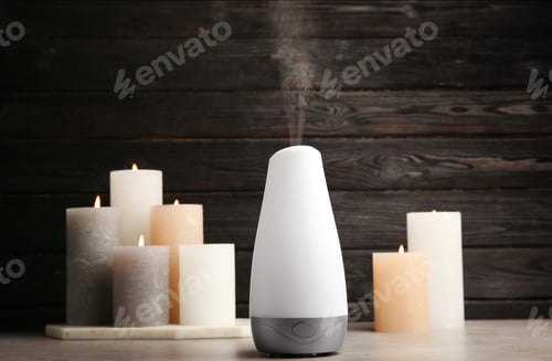 Preview: Modern aroma humidifier with candles on table against dark wooden background, space for text
