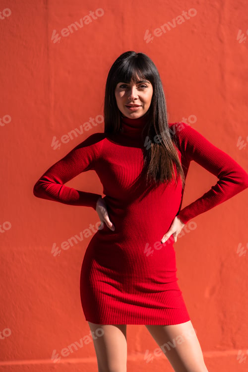 Preview: Posed brunette girl in a dress in spring. Caucasian pretty a red background