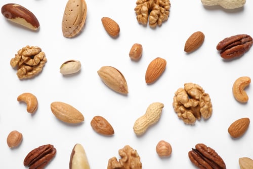 Preview: Different delicious nuts on white background, flat lay