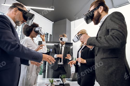 Preview: Group of five multiethnic people working with virtual reality glasses in modern office. New
