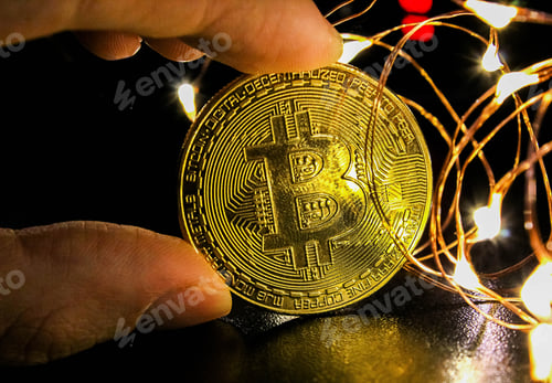 Preview: Mining bitcoin concept. Golden Bitcoin currency. Festive atmosphere on black background with lights.