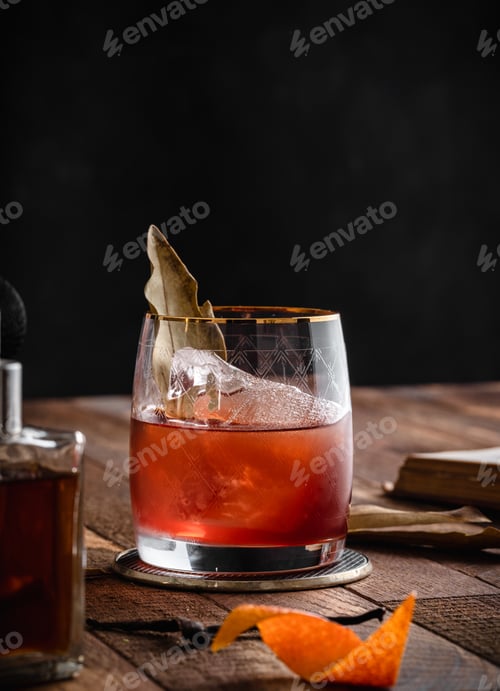 Preview: Vertical shot of a brown cocktail in a glass placed on a wooden surface with other drinks