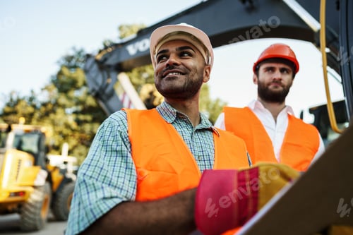 Preview: Two men engineers discussing their work standing against construction machines