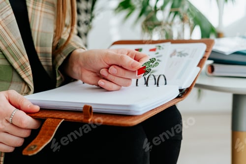 Preview: Close up picture of woman girl puts a sticker on notepad notebook page