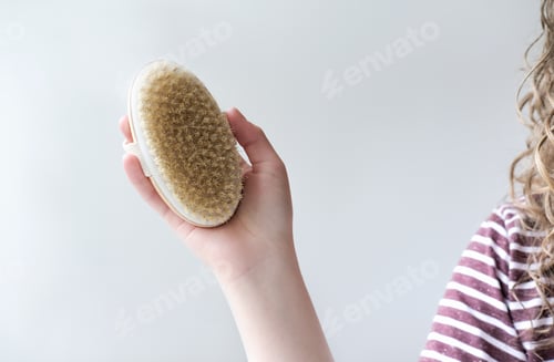 Preview: woman holding a brush for dry massage.