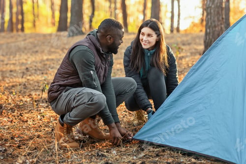 Preview: Man and woman making tent together, having conversation