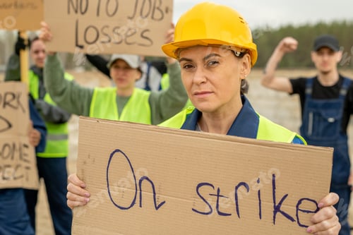 Preview: Middle aged female builder holding placard