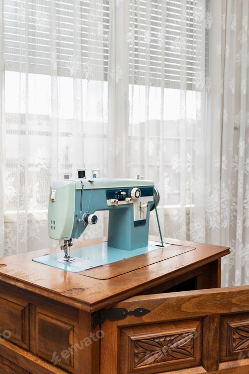 Preview: antique sewing machine on wooden furniture at home