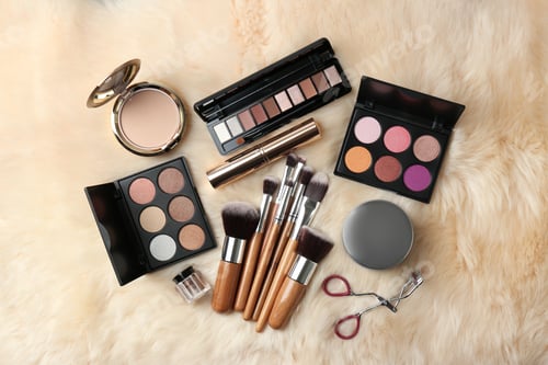 Preview: Set of different professional makeup products on furry plaid, flat lay
