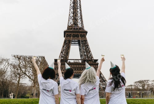 Preview: Portrait of four girls with glasses of champagne near the Eiffel Tower.