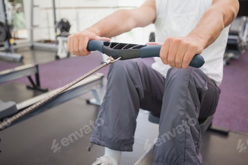 Preview: Fit Man Working Out On Rowing Machine At The Gym