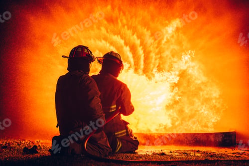 Preview: Fearless Firefighters Battling Blaze with Water and Extinguishers.