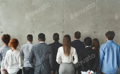 Preview: Business team looking at grey wall with empty space