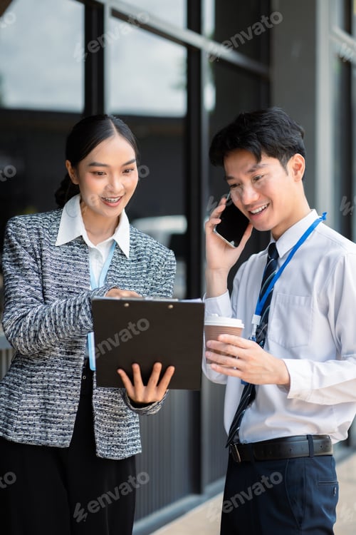 Preview: Business team reviewing and discussing a business project outside office building.