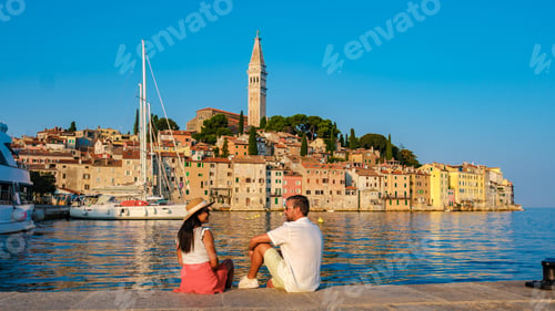 Preview: A couple enjoys a peaceful evening by the waterfront as the sun sets in Rovinj, Croatia