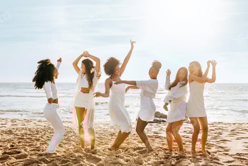 Preview: Full length shot of happy multiracial female friends dancing on the beach, having fun, enjoying hen