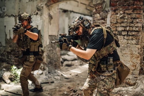 Preview: Group of air soft players shooting from rifles in demolished building.