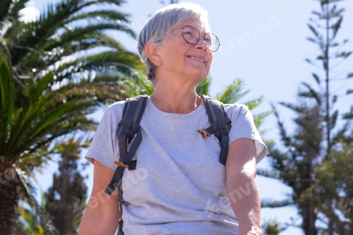 Preview: Portrait of handsome smiling senior woman sitting relaxing in public park enjoying freedom and good