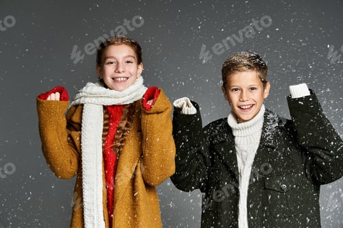 Preview: Two joyful children in cozy winter attire, celebrating snowfall in a cheerful atmosphere