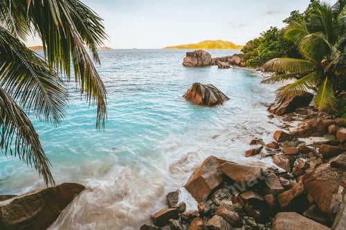 Preview: Sunset at tropical beach Anse Patates with granite boulders on La Digue Island, Seychelles