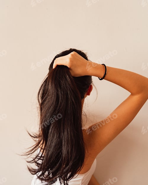 Preview: Woman Holds Long Hair Up Indoors