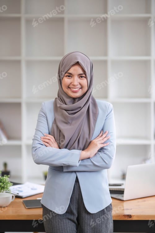 Preview: A portrait of a beautiful and professional Asian Muslim businesswoman stands in the office with her