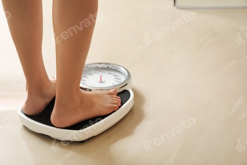 Preview: Woman standing on scales indoors, space for text. Overweight problem