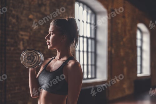 Preview: Young girl with dumbbells in the loft