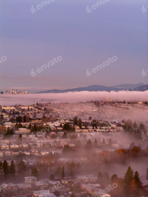 Preview: Sunrise Over Foggy Burnaby Cityscape at Dawn with Mountain Background in British Columbia