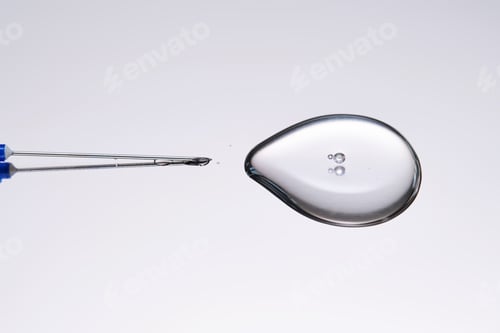 Preview: A drop of medicine flowing from a syringe with a needle.