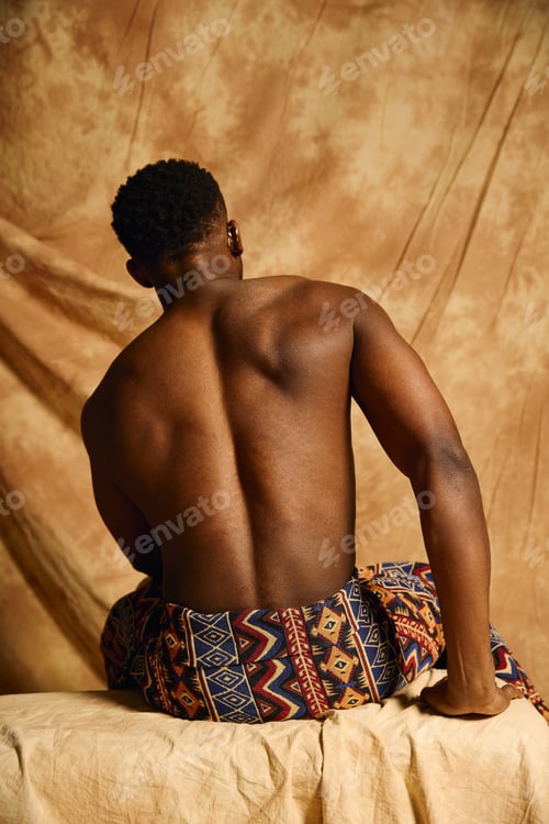 Preview: Young African American man showcases his charisma with a confident pose against a warm backdrop