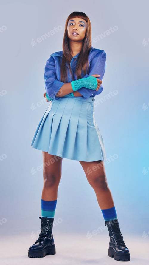 Preview: Arms crossed, fashion and portrait of an edgy woman isolated on a blue studio background. Confident