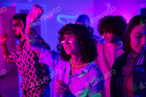 Preview: Youthful brunette girl in white blouse and eyeglasses dancing among friends