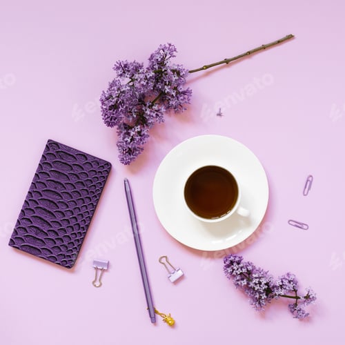 Preview: A cup of tea, notebooks, a pen, a bouquet of lilacs on a purple background. Purple spring flowers