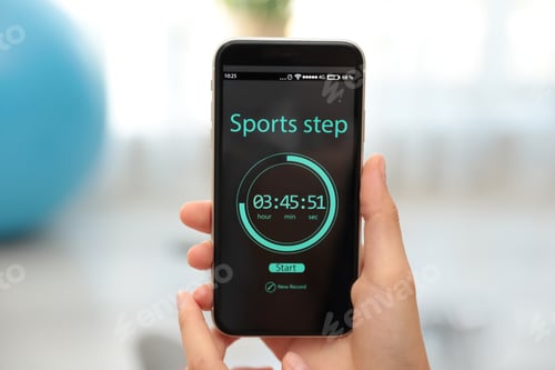 Preview: Young woman using fitness app on smartphone indoors, closeup