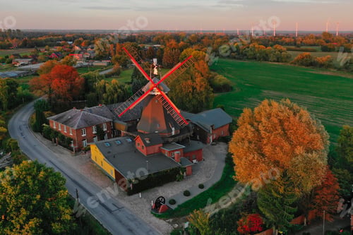 Preview: Aerial view of an old windmill and farmhouses in the countryside at Autumn