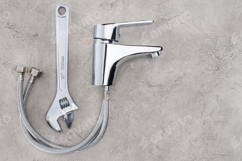 Preview: top view of water mixer and pipe wrench on concrete surface
