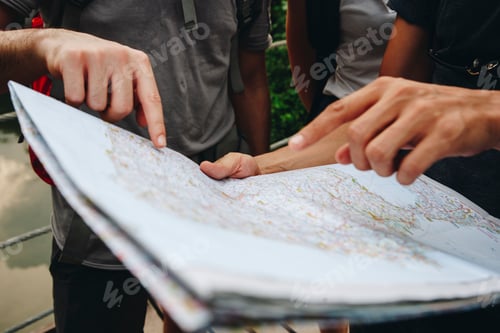 Preview: Group of friends looking at a map together travel and teamwork concept