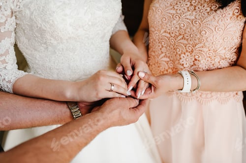 Preview: Bride on wedding day holding her mother's and father's hands. Concept of relationship between mom