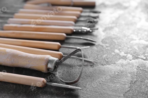Preview: Set of different clay crafting tools on grey table, closeup. Space for text