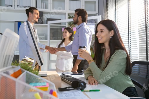 Preview: Group of multiethnic young business friends gathered in a modern office conference room