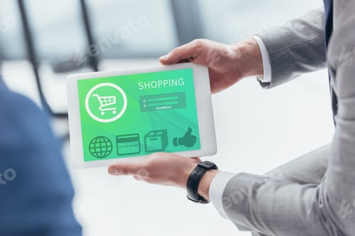Preview: partial view of businessman holding digital tablet with shopping application