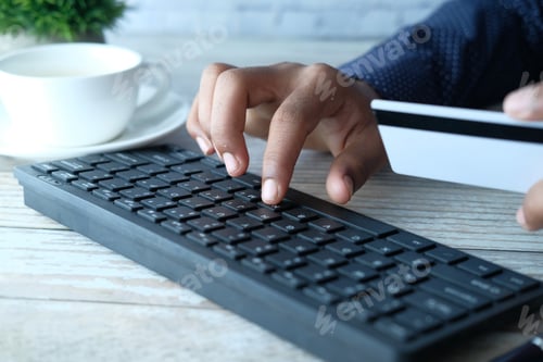 Preview: man hands holding credit card and using laptop shopping online