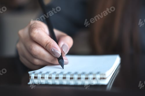 Preview: a woman's hands writing on notebook on the table