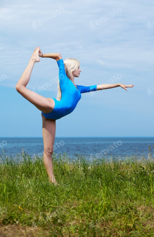 Preview: Outdoor Portrait Of Young Beautiful Blonde Woman Gymnast Training On Green Grass